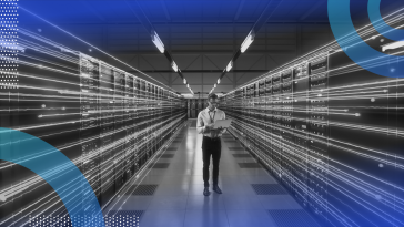 A tech worker stands between servers