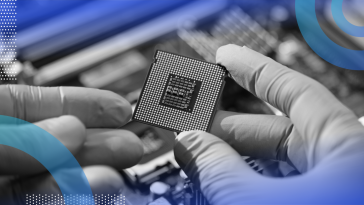 Gloved hands hold a computer chip