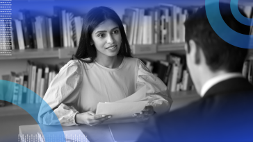 Hiring manager interviewing an applicant and reviewing resumes