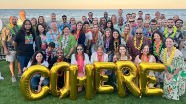 Cohere Health team members gather for a group photo by the ocean during an offsite