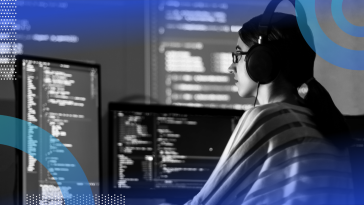 developer writing C# code with multiple monitors
