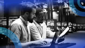 Two developers reviewing code in a hardware facility