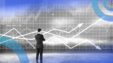 A man in a suit ponders graph trend lines