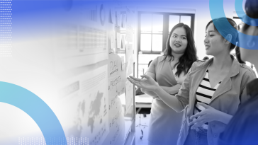 Three product managers look at a whiteboard