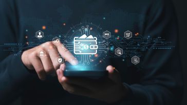 A finger points to the screen of a mobile device with a wallet hovering over it to represent mobile wallet and crypto technology.