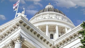 Three flags fly outside the California State Capitol.