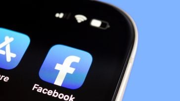 Image of the Facebook app logo in the top-right corner in the screen of a mobile phone.