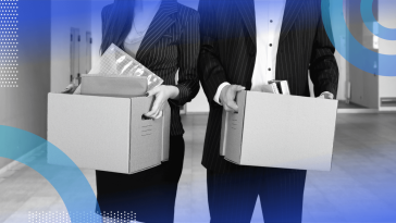 Two office workers carry boxes of belongings after being fired