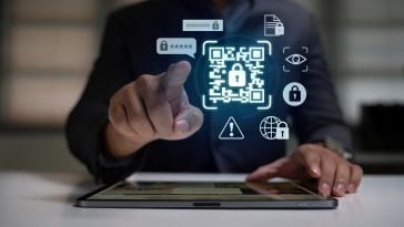 A person interacts with a digital tablet displaying a glowing QR code surrounded by security icons, symbolizing cybersecurity and data protection.