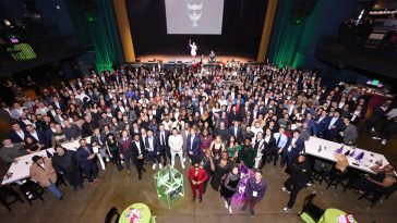 PrizePicks team members pose for a large group photo during a company holiday party