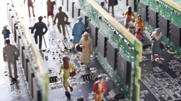 A photo of mini figures walking on a mother board to show the idea of agentic AI. 