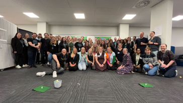 Xero employees pose for a large group photo during an event in the company’s office