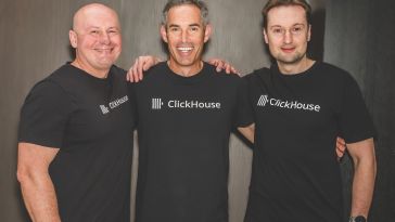 Three men smiling, wearing black "ClickHouse" t-shirts. They stand close together in a friendly pose against a plain dark background, conveying camaraderie.