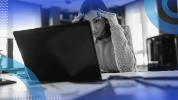 A woman looks frustrated while working on her laptop