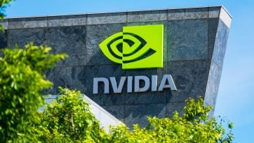 Granite building facade with the Nvidia logo in green, partially blocked by a green tree.