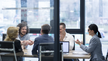 two people shake hands in conference room