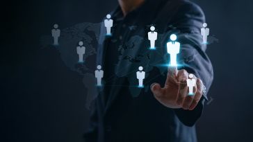 A person in a suit interacts with a holographic map showing global figures. The image suggests networking and digital connections across different regions.