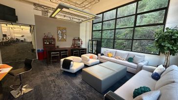 A lounge area with a couch situated next to a window in Philo’s office