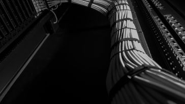 A collection of gray cables is connected, overlayed on top of a black background.