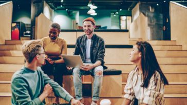Four coworkers having a casual meeting in a modern office