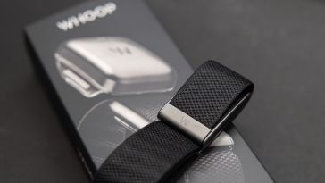 A black WHOOP device sits on top of a label featuring the WHOOP label.