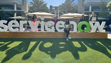 ServiceNow interns pose next to the sign outside. 