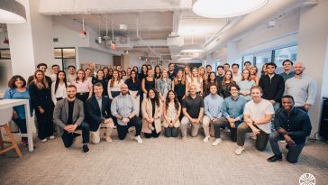Mirakl team members posing for a large group photo in the company’s office