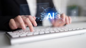 A close-up shot shows a person's hands typing on a white keyboard with a glowing digital "AI" hologram hovering above the keys.