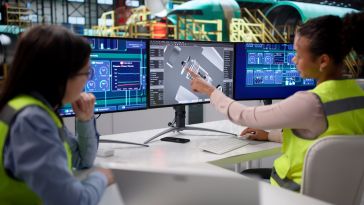 Engineers looking at a computer screen with blueprints