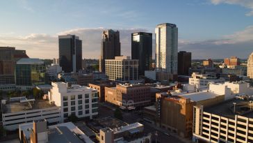 Downtown Birmingham, Alabama skyline with high-rise office buildings and the Alabama Theatre visible at sunset.