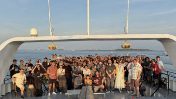 Doximity team members pose for a photo on a boat during a company event
