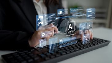 A person in a business suit types on a keyboard while various digital holographic interfaces representing artificial intelligence, intelligent systems and data processing float in front of them.