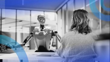 A robot talks to a woman across a desk
