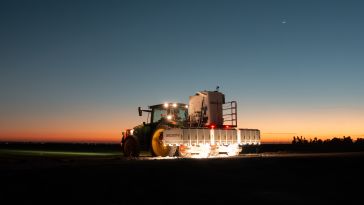 A Carbon Robotics LaserWeeder G2 moving across a field at sunset