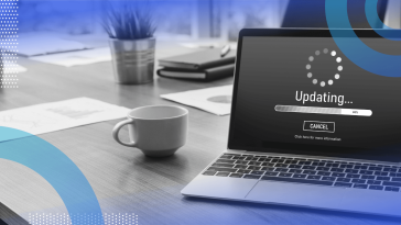 A laptop showing a software update with a coffee cup nearby