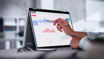 A hand uses a pen to point to a visualization on a big data analytics tool.
