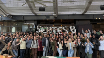 Closinglock employees pose for a large group photo in front of a balloon display that spells out “Series B.” 