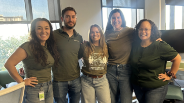 Kris McKee poses for a photo with three other colleagues during a company event