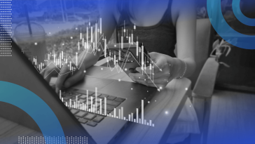 A woman looks at financial data on her phone and laptop