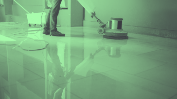 A janitor waxes a floor