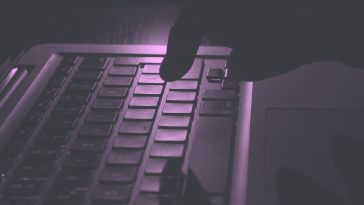 Shadowy hand typing on keyboard.