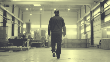 Factory worker walking, shot from behind.