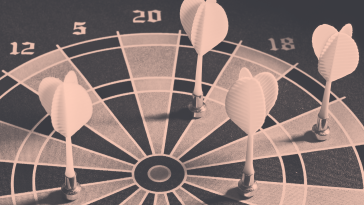 Four darts that have missed their targets on the dartboard. 