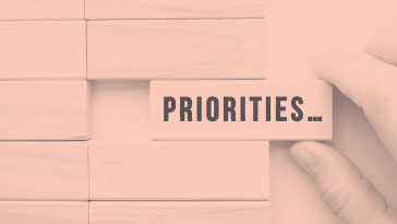 A person pulling a block that says "Priorities..." from a stack.
