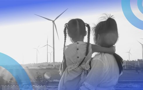 A woman and little girl look at wind turbines