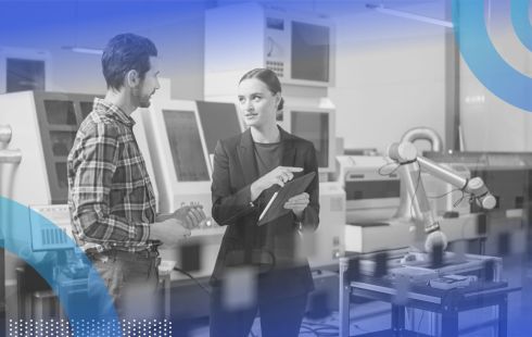 Two people converse amidst several computers and machines