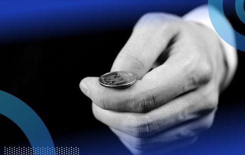 A hand prepares to flip a coin