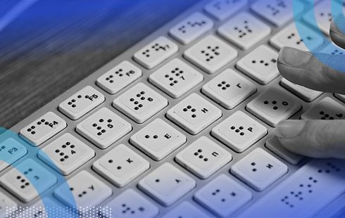 A hand typing on a braille computer keyboard.