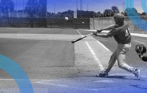 A baseball player swinging at a ball on a baseball field with a catcher behind him.