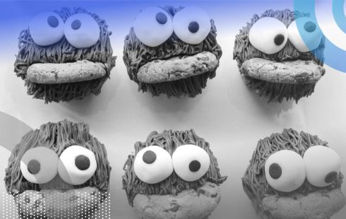 Six Cooke Monsters with googly eyeballs are eating cookies .